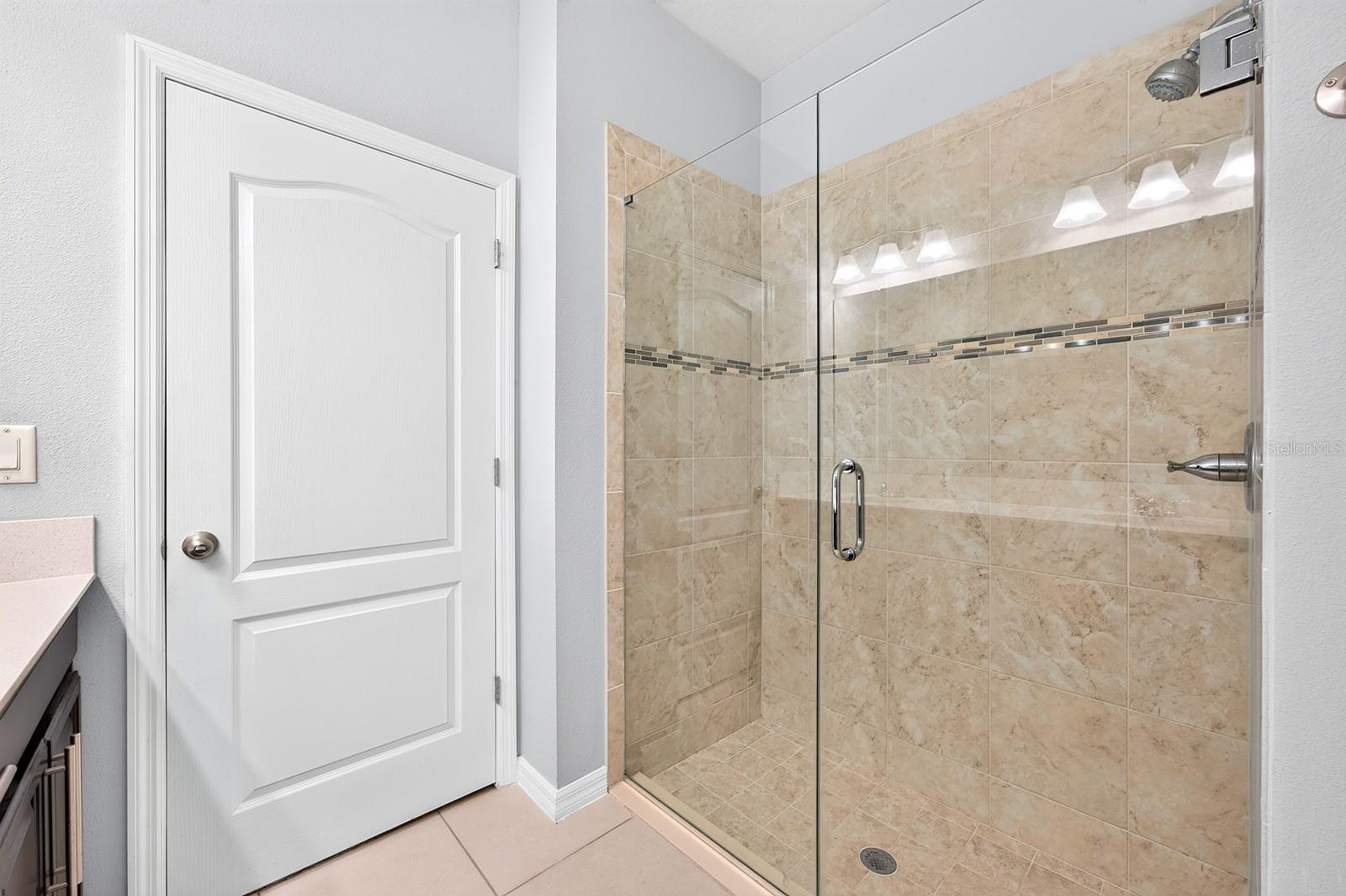 The private Bath features dual sinks, a STEP-IN SHOWER and a linen closet for additional storage.