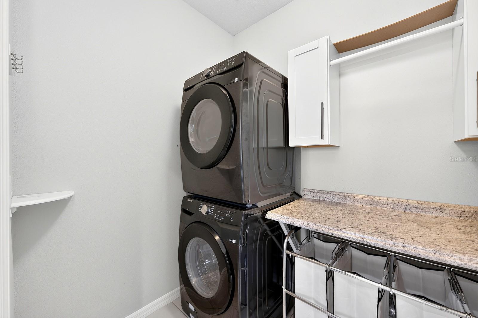 A DEDICATED LAUNDRY ROOM on the first floor includes a GRANITE FOLDING COUNTER and cabinetry to keep everything organized.