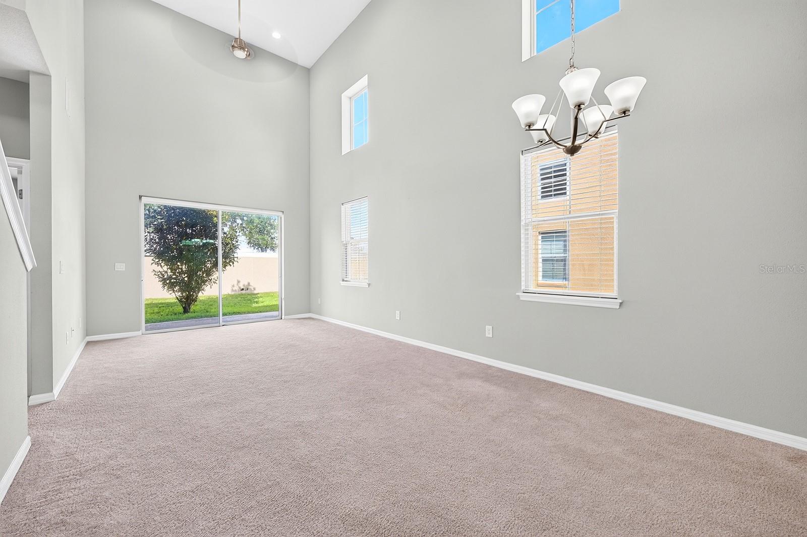 Two-story windows fill the Living/Dining Room with NATURAL LIGHT, while sliding glass doors extend the living space outdoors.