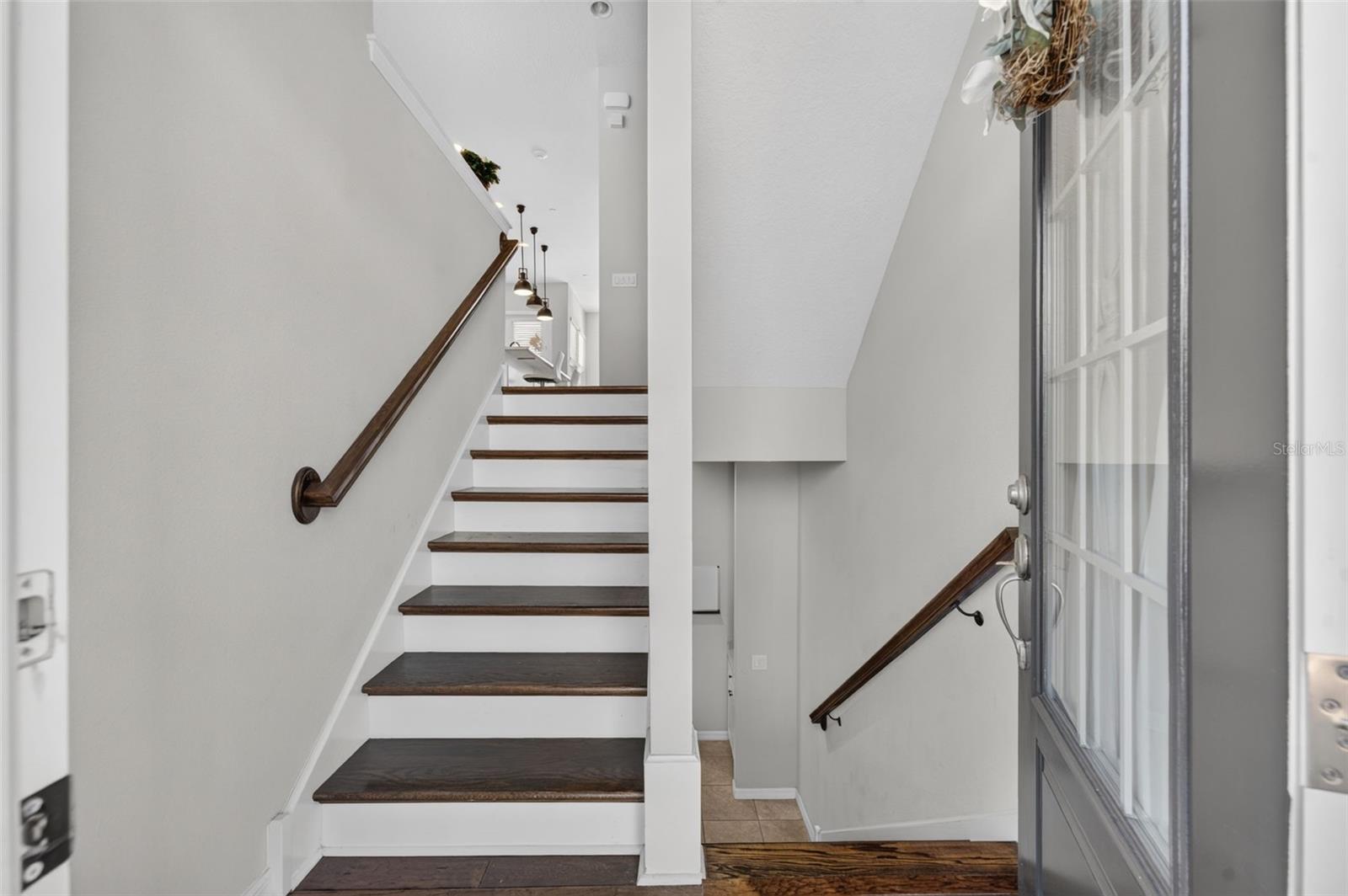 Stairwell upon entry; covered with hardwood flooring on all 3 stairways; short flight up goes to main living area; one short flight down there's a bedroom, full bath and garage entry. Top level has 2 Bedrooms, 2 full baths and a laundry room