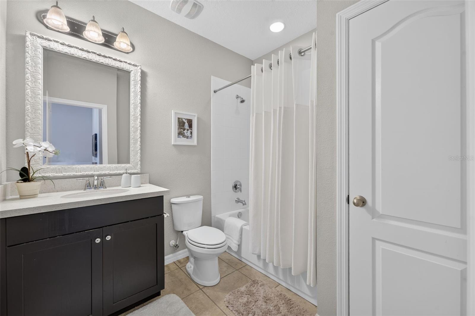 Full bathroom is adjacent to secondary bedroom on the top floor and features a tub/shower combination