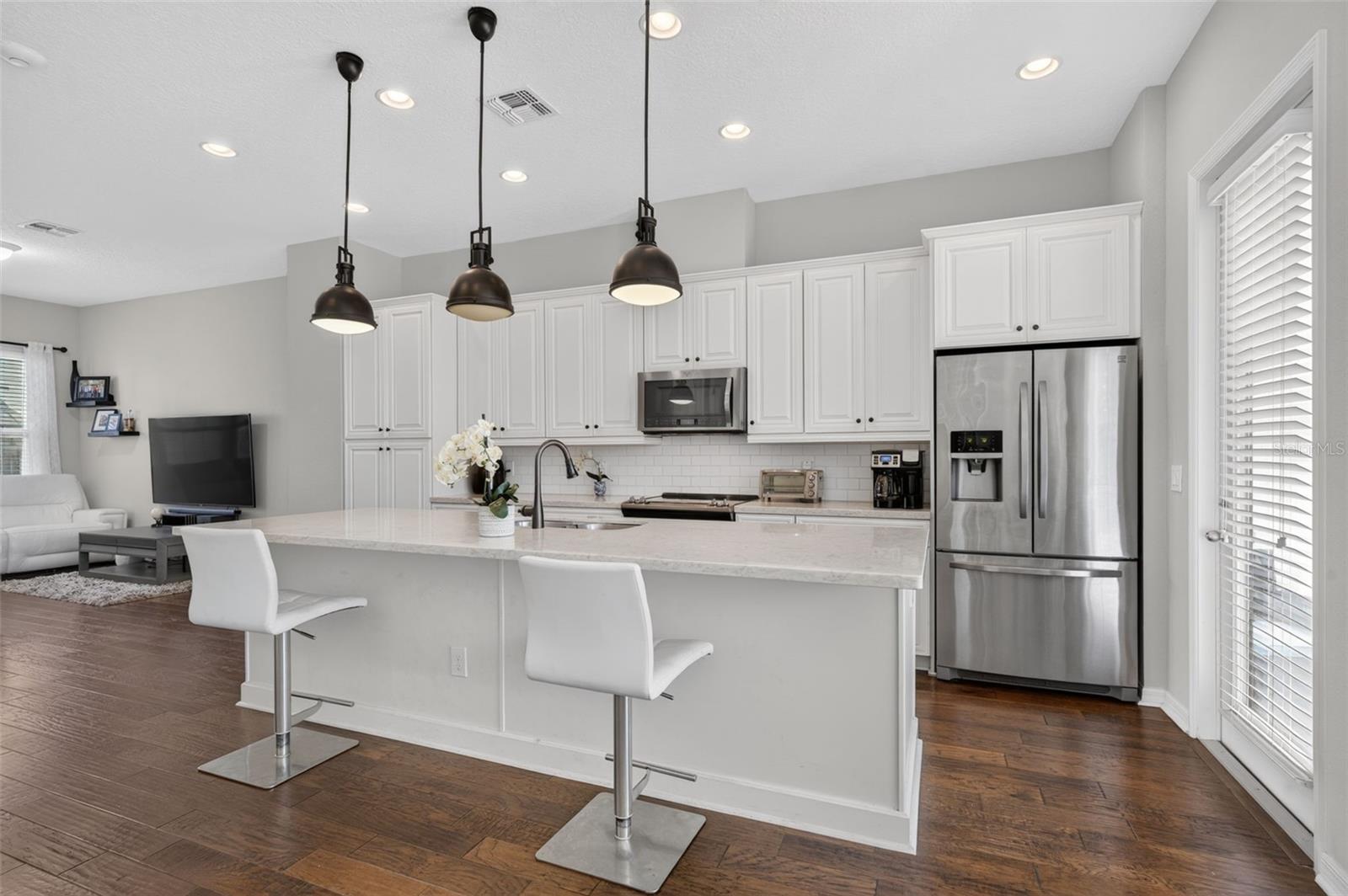 The Luxurious kitchen features solid stone counters, 42-inch cabinetry, laminate wood flooring and stainless appliances.