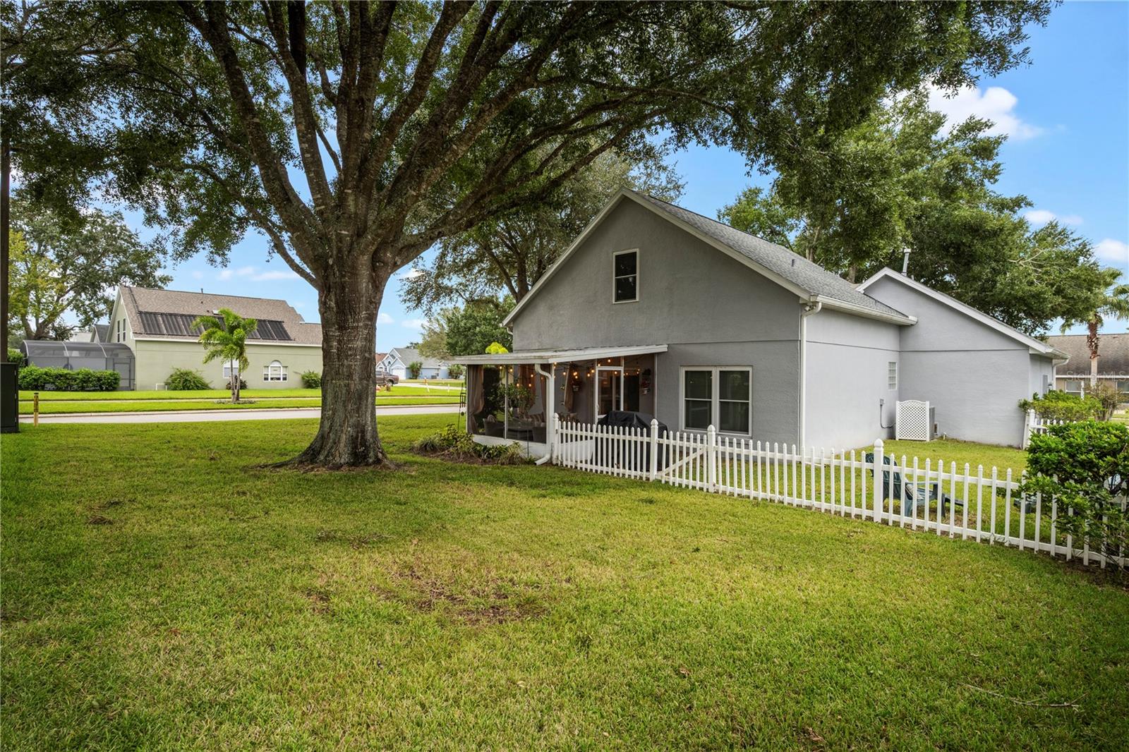Rear view, backyard extends past picket fence