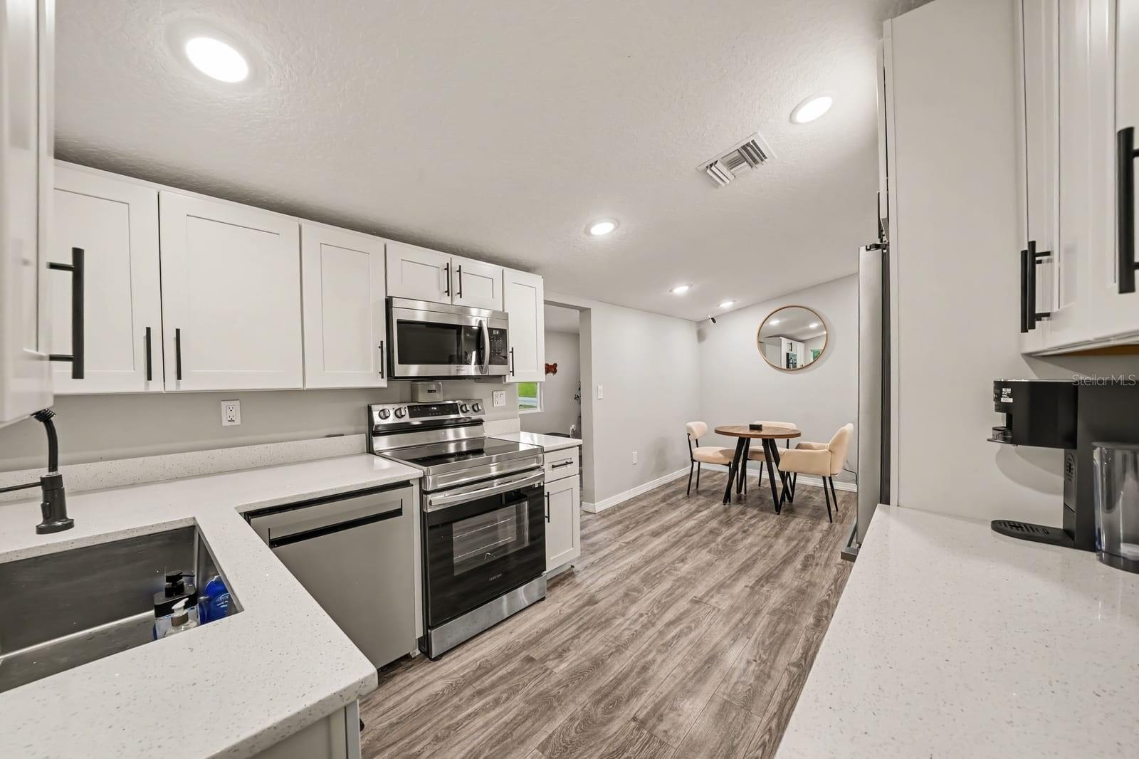 Open-Concept Kitchen Flowing Into Bright Dining Area with Natural Light