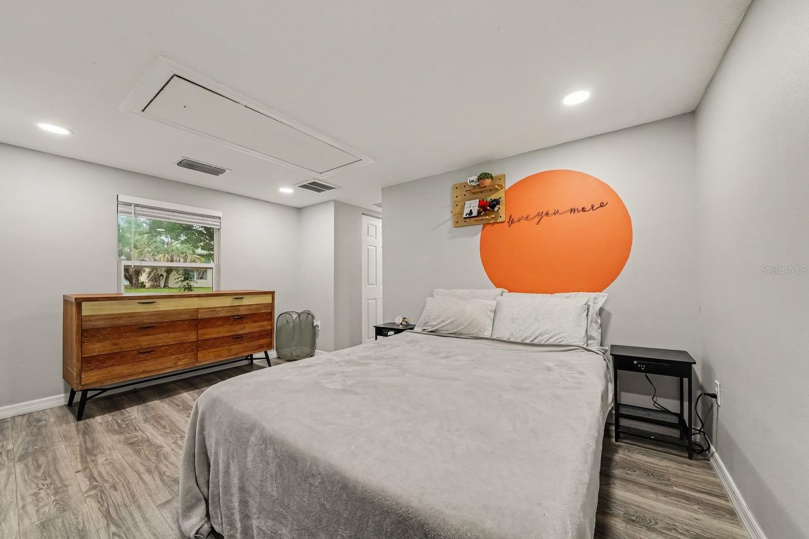 Bright Primary Bedroom with Large Window and Mid-Century Furnishings
