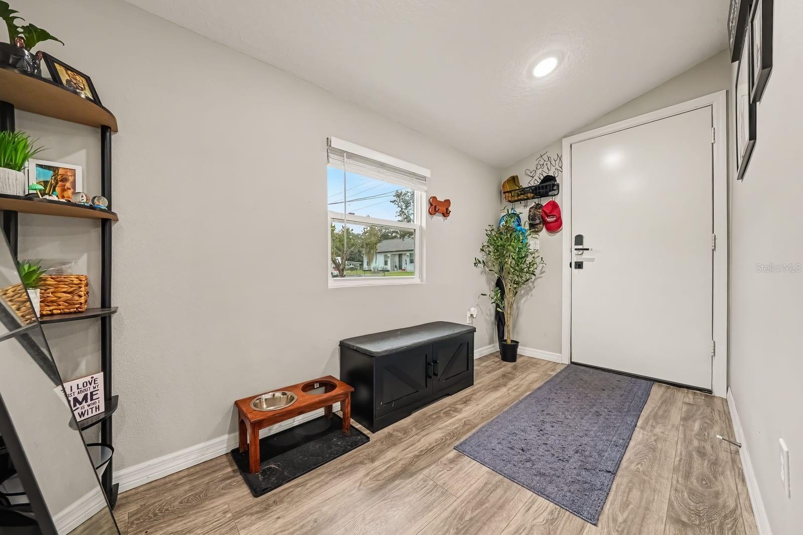 Bright mudroom entry with hardwood floors and storage shelving