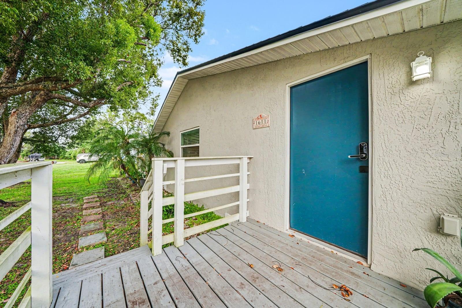 Covered Deck Entry with Teal Door & White Rail Accents