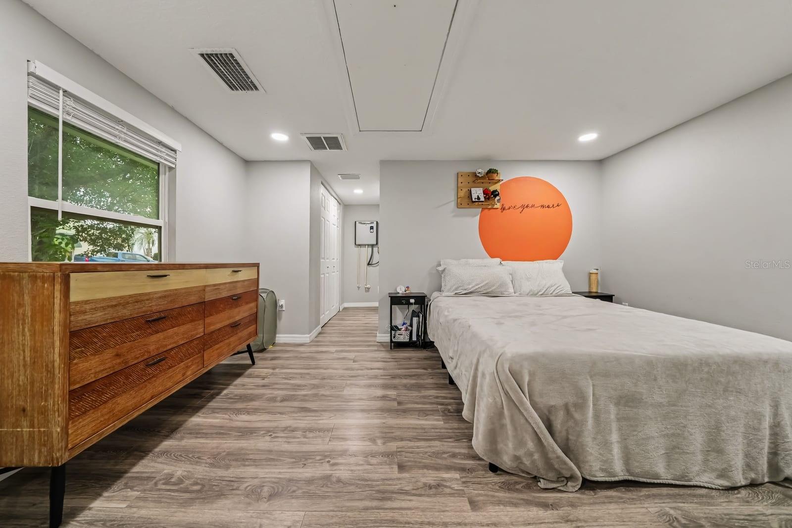 Spacious Primary Bedroom with Natural Light and Hardwood Flooring