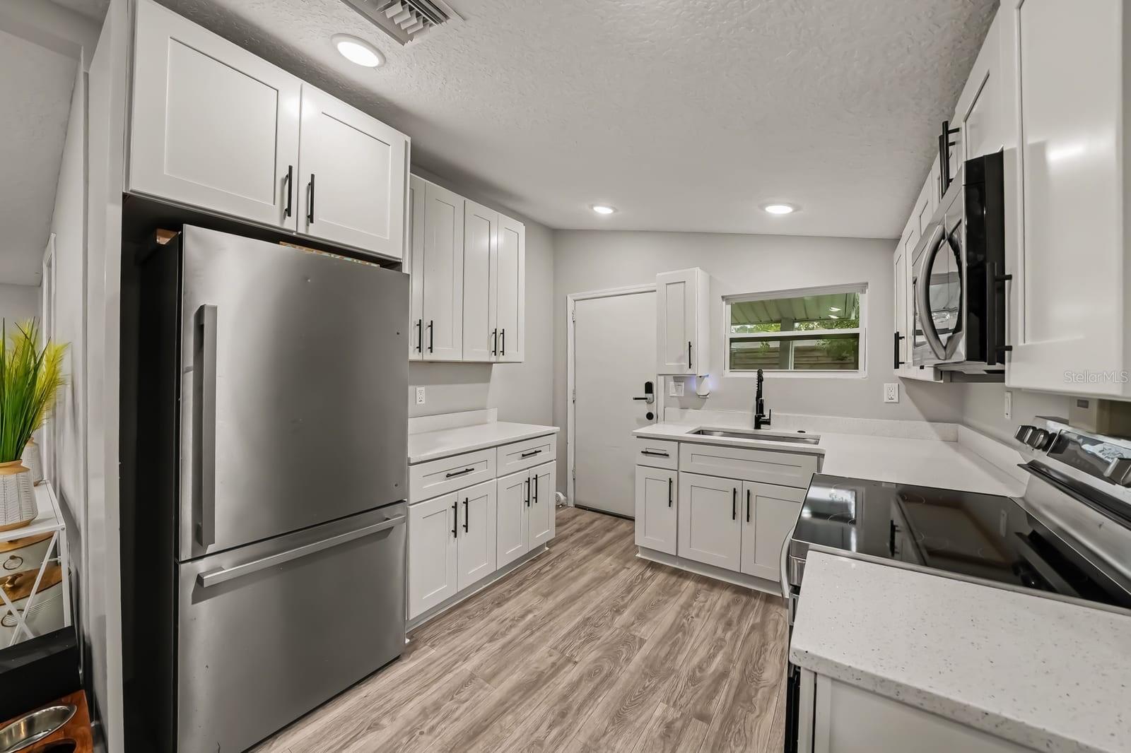 Spacious Kitchen with Stainless Steel Appliances and White Cabinetry