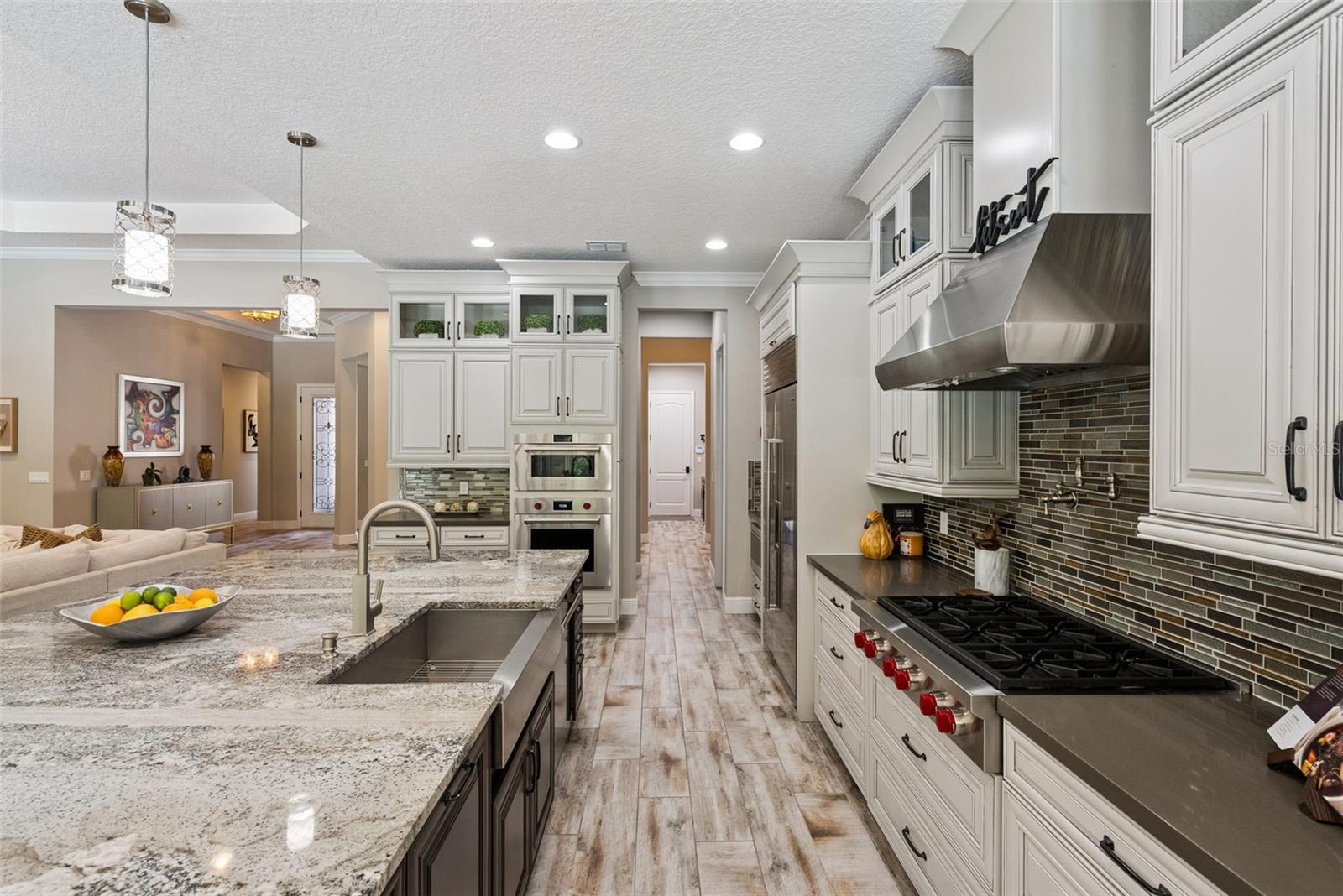 Gourmet kitchen featuring custom cabinetry, Sub-Zero Wolf appliance packages and oversized granite island w/ seating for 6