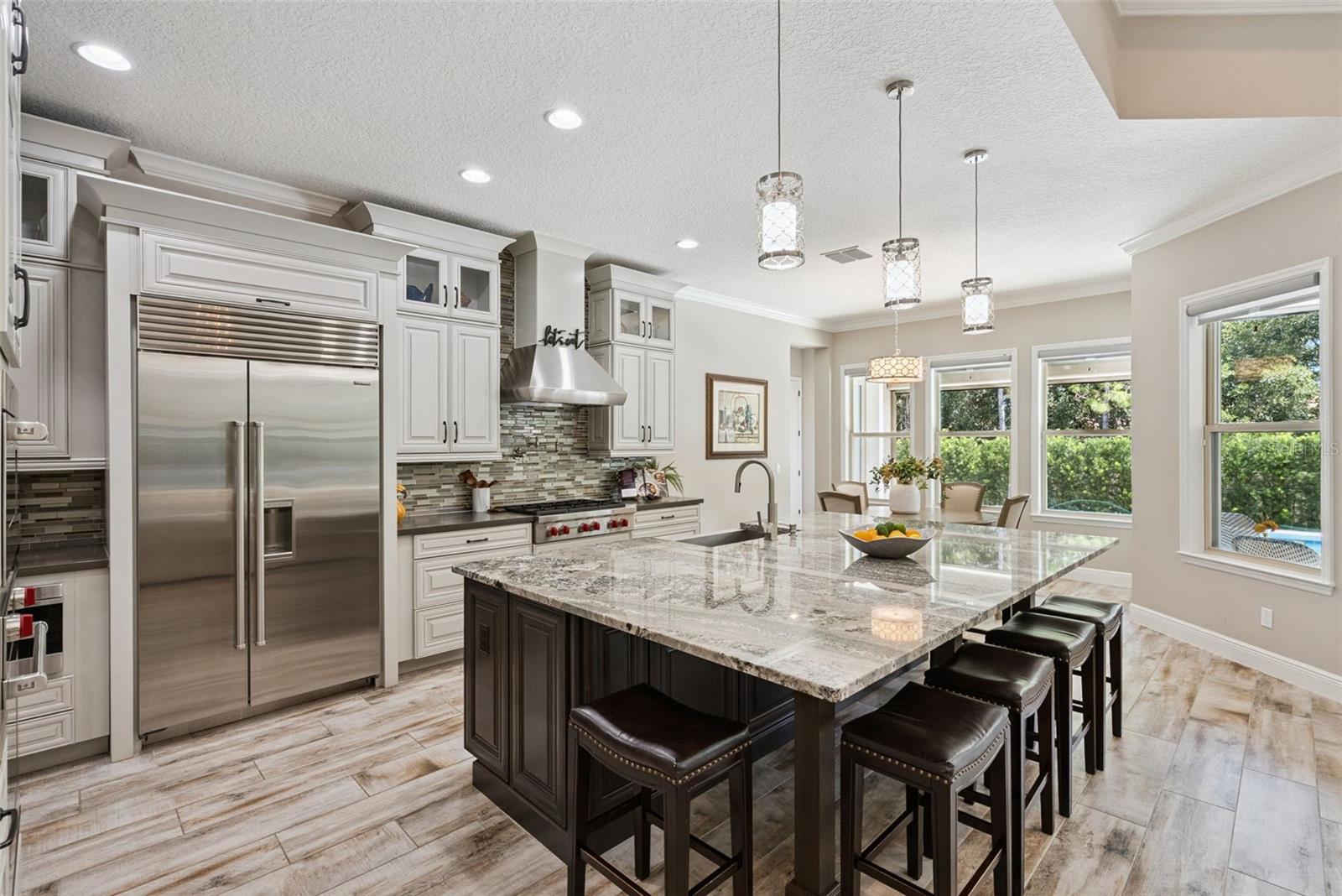 Gourmet kitchen featuring custom cabinetry, Sub-Zero Wolf appliance packages and oversized granite island w/ seating for 6
