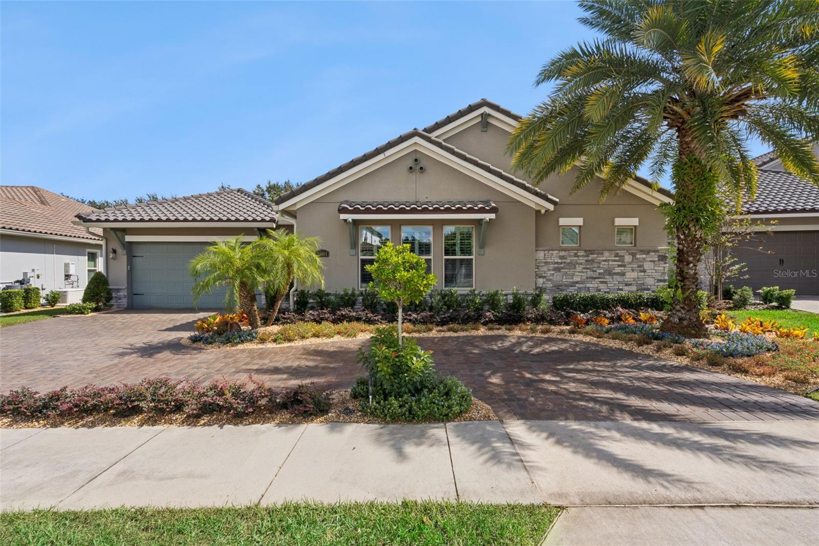 Elegant, Mediterranean-inspired exterior w/ tile roof, paver driveway, lush tropical landscaping and a gated courtyard entrance Elegant, Mediterranean-inspired exterior w/ tile roof, paver driveway, lush tropical landscaping and a gated courtyard entrance