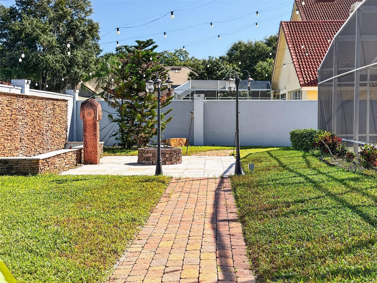 Walled backyard with putting green and paved gardens