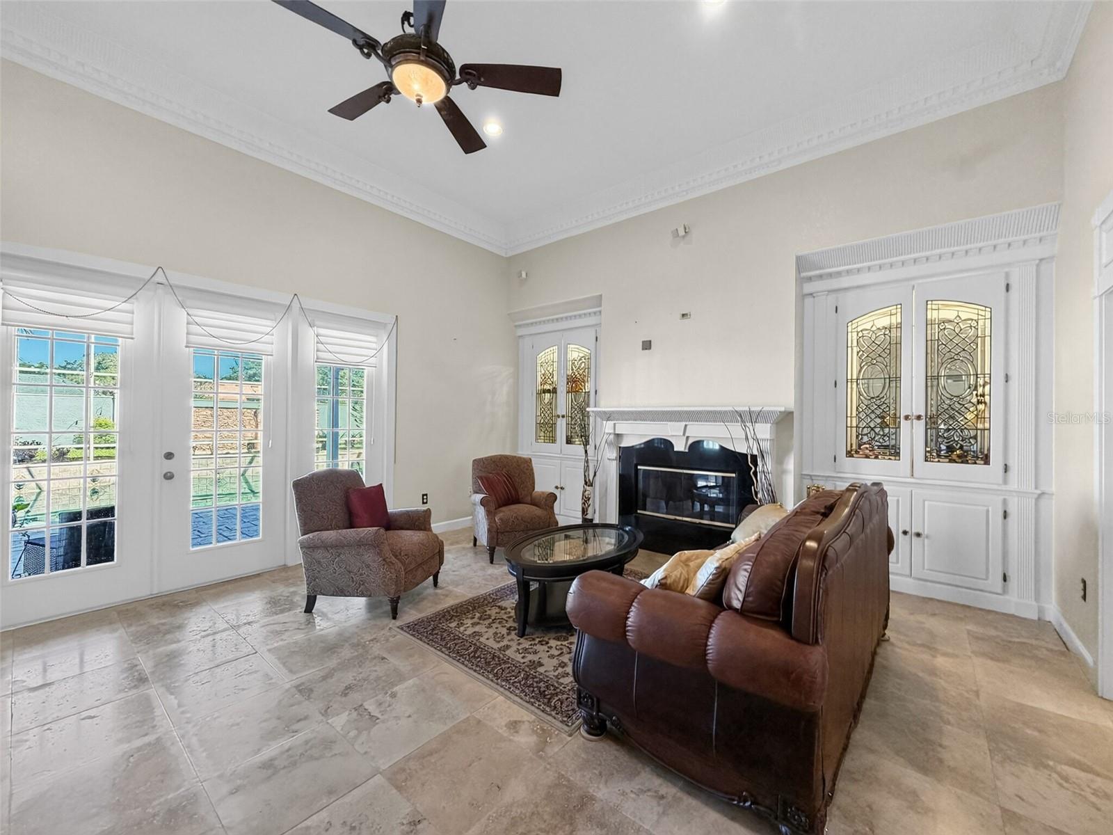 Living room with built-in glass cabinetry and surround sound