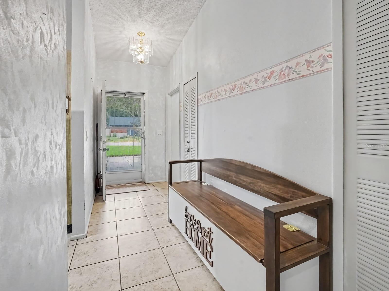 Entryway with tile flooring, glass doors & decorative bench Entryway with tile flooring, glass doors & decorative bench