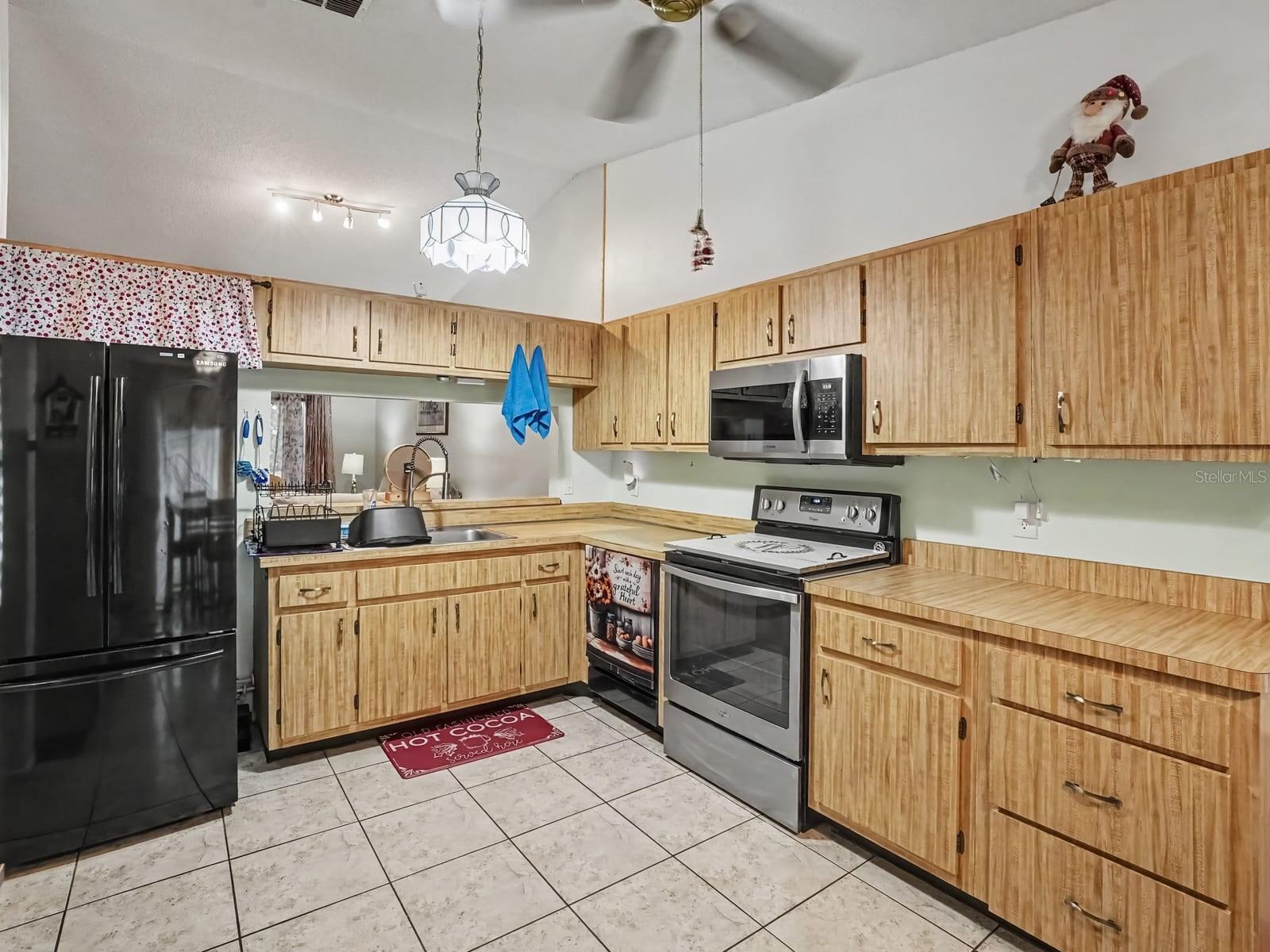 Wood Cabinetry Kitchen with Black Appliances & Tile Flooring