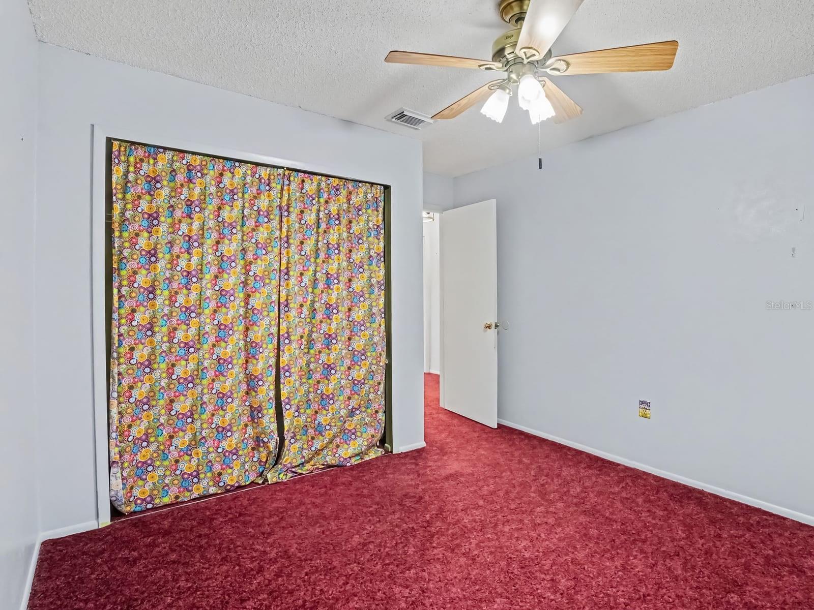 Generous Bedroom with Closet and Red Carpet Flooring