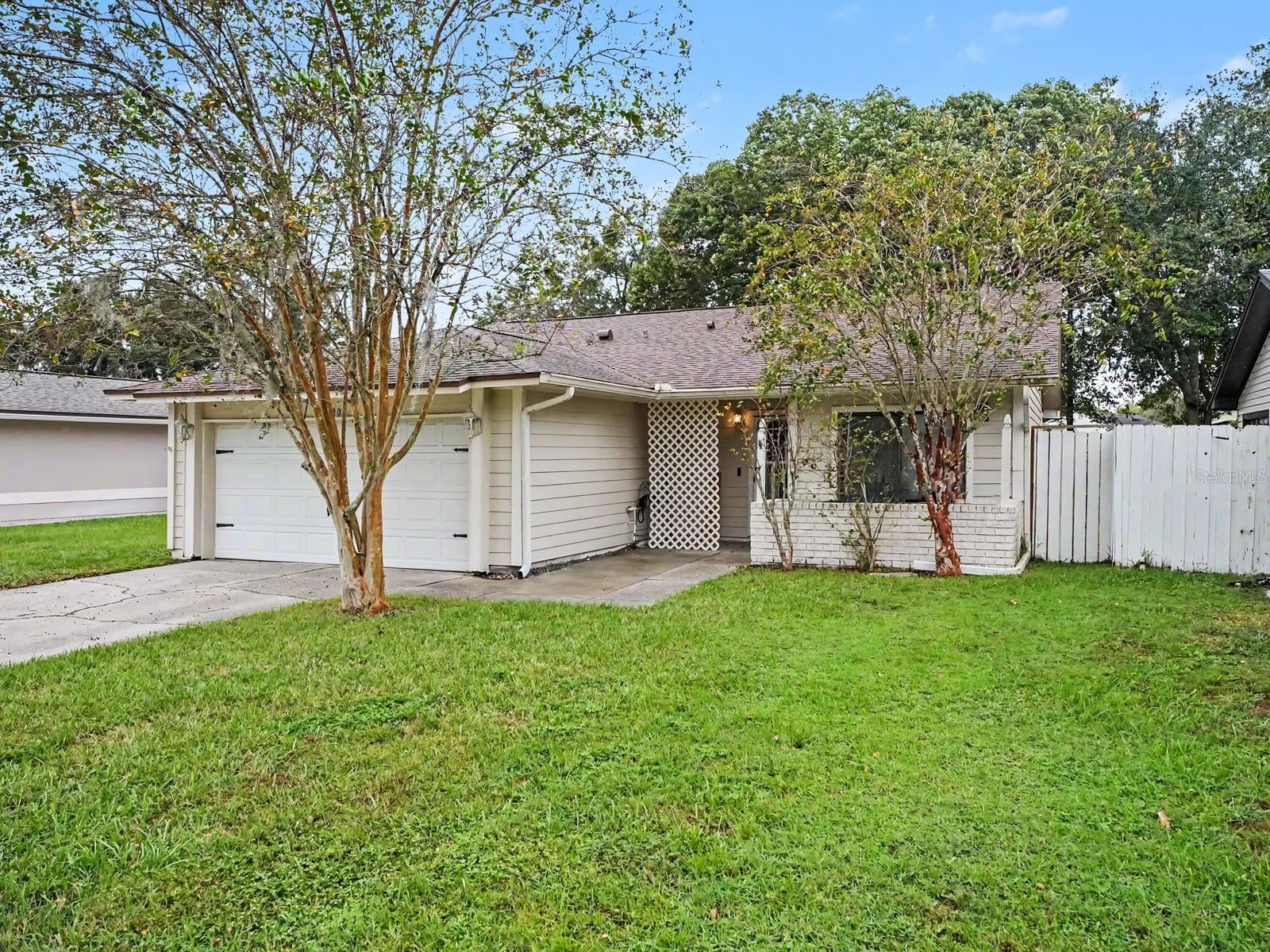Welcoming entrance flanked by mature trees & white fencing Welcoming entrance flanked by mature trees & white fencing