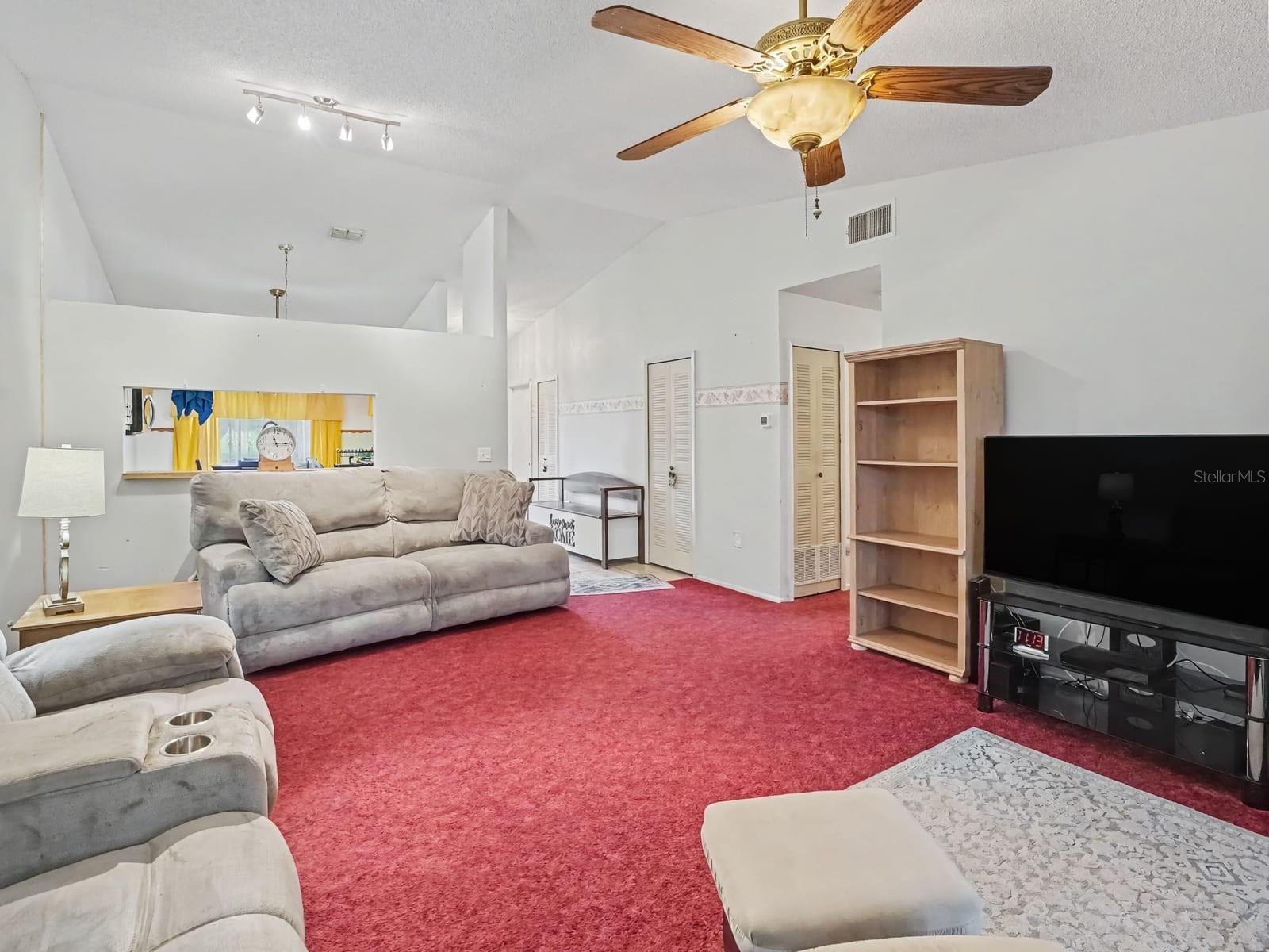 Bright great room with vaulted ceiling, ceiling fan & entertainment space