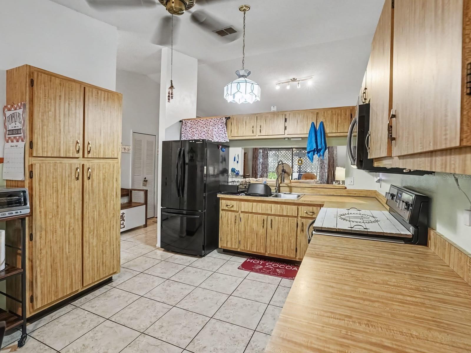 Spacious Kitchen Layout with Wood Cabinetry & Island Workspace