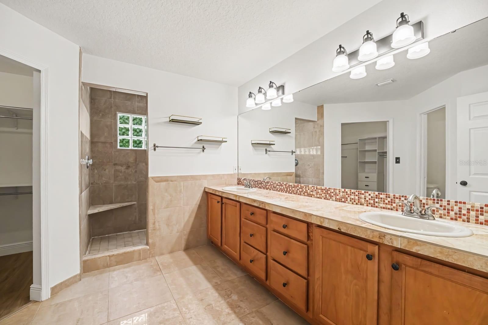 Master Bath with Double Vanity, Tile Accents, and Walk-In Shower