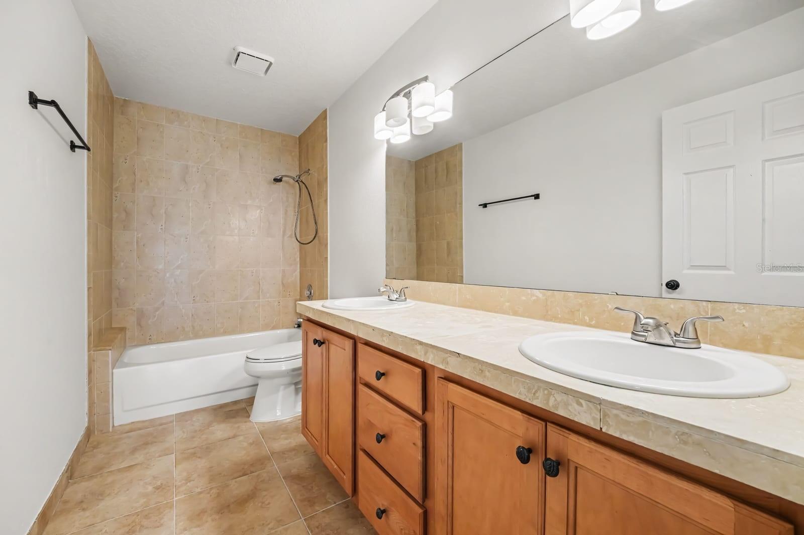 Master Bath Featuring Dual Vanities, Soaking Tub, and Tiled Shower