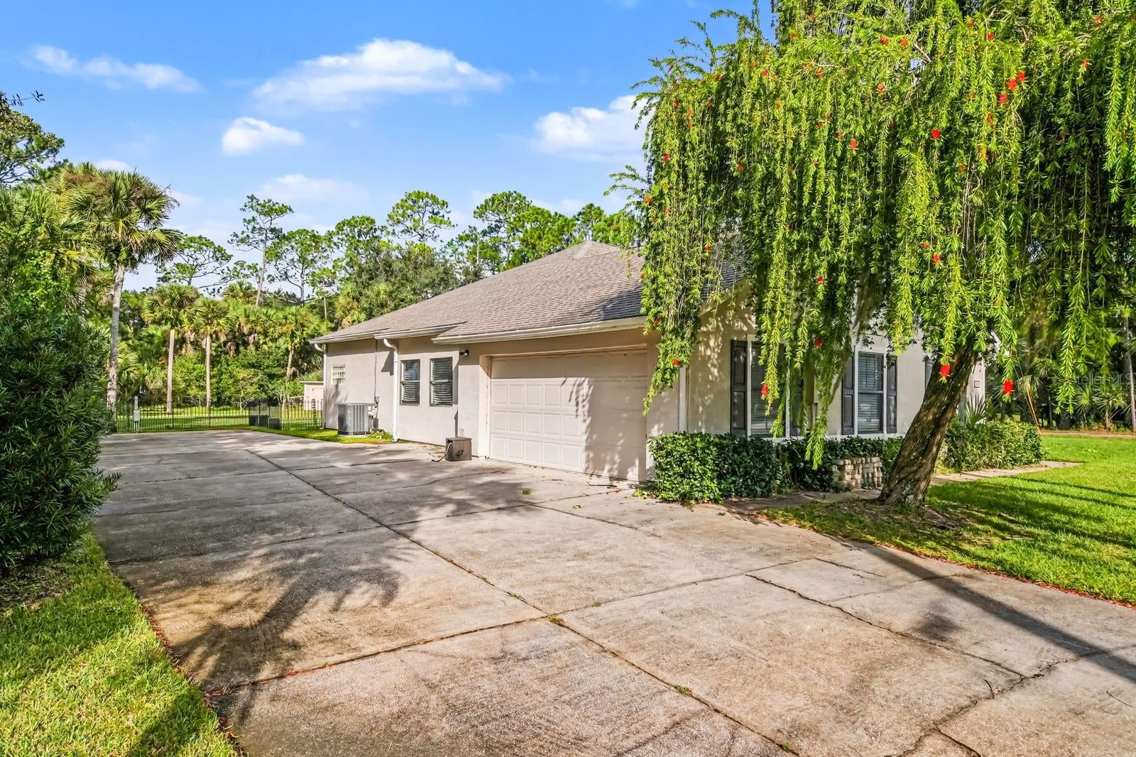Front elevation features attached garage, mature trees, and welcoming approach