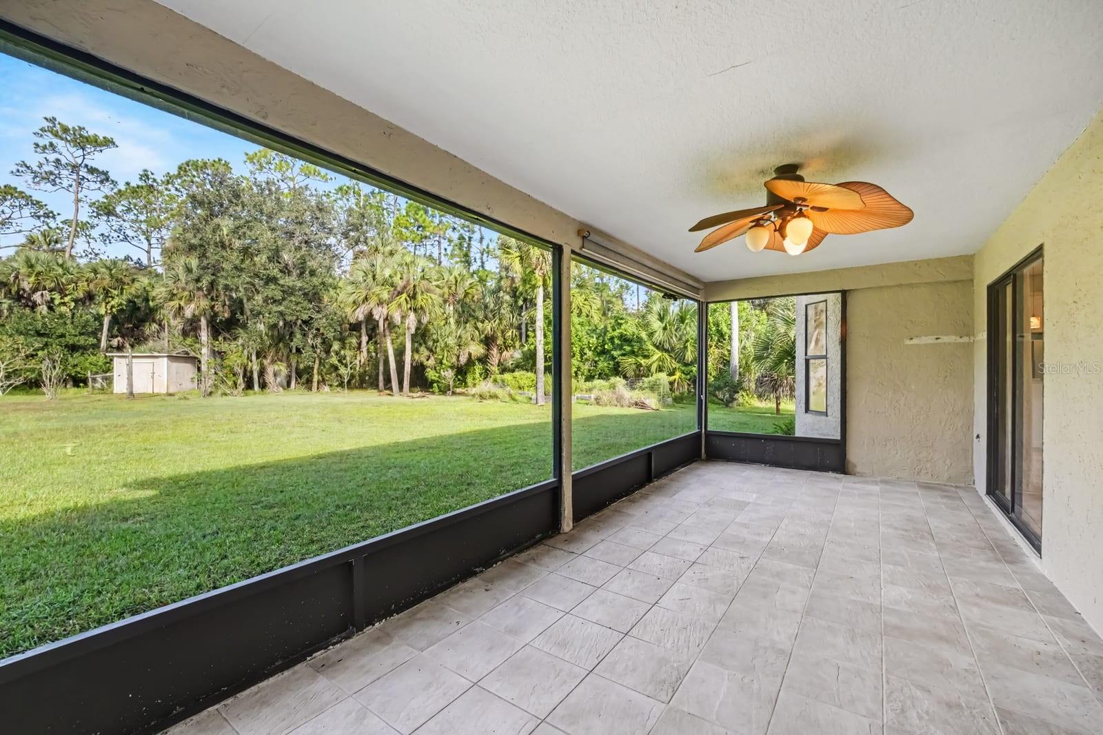 Screened Lanai With Tile Flooring & Expansive Lawn Views