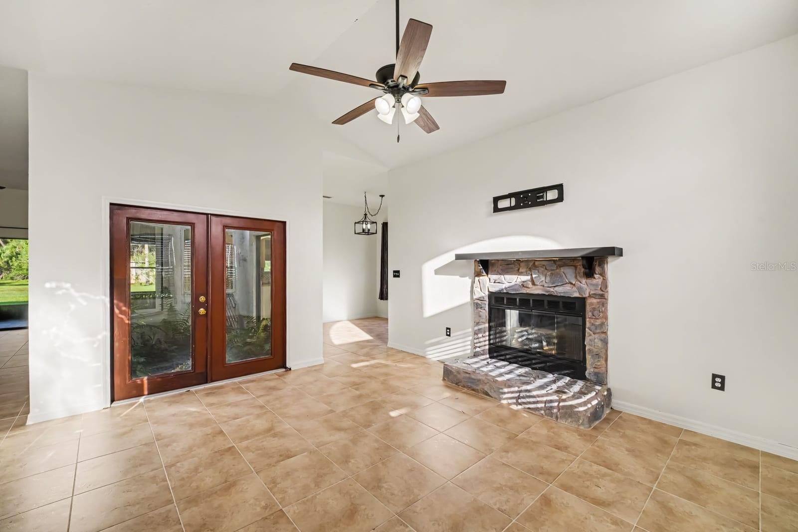Fireplace focal point with soaring ceilings and abundant natural light