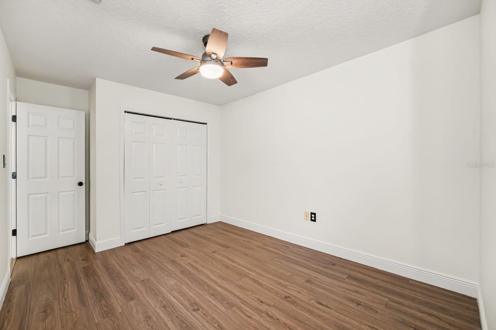 Master Bedroom With Double Closets, Ceiling Fan, and Hard Flooring