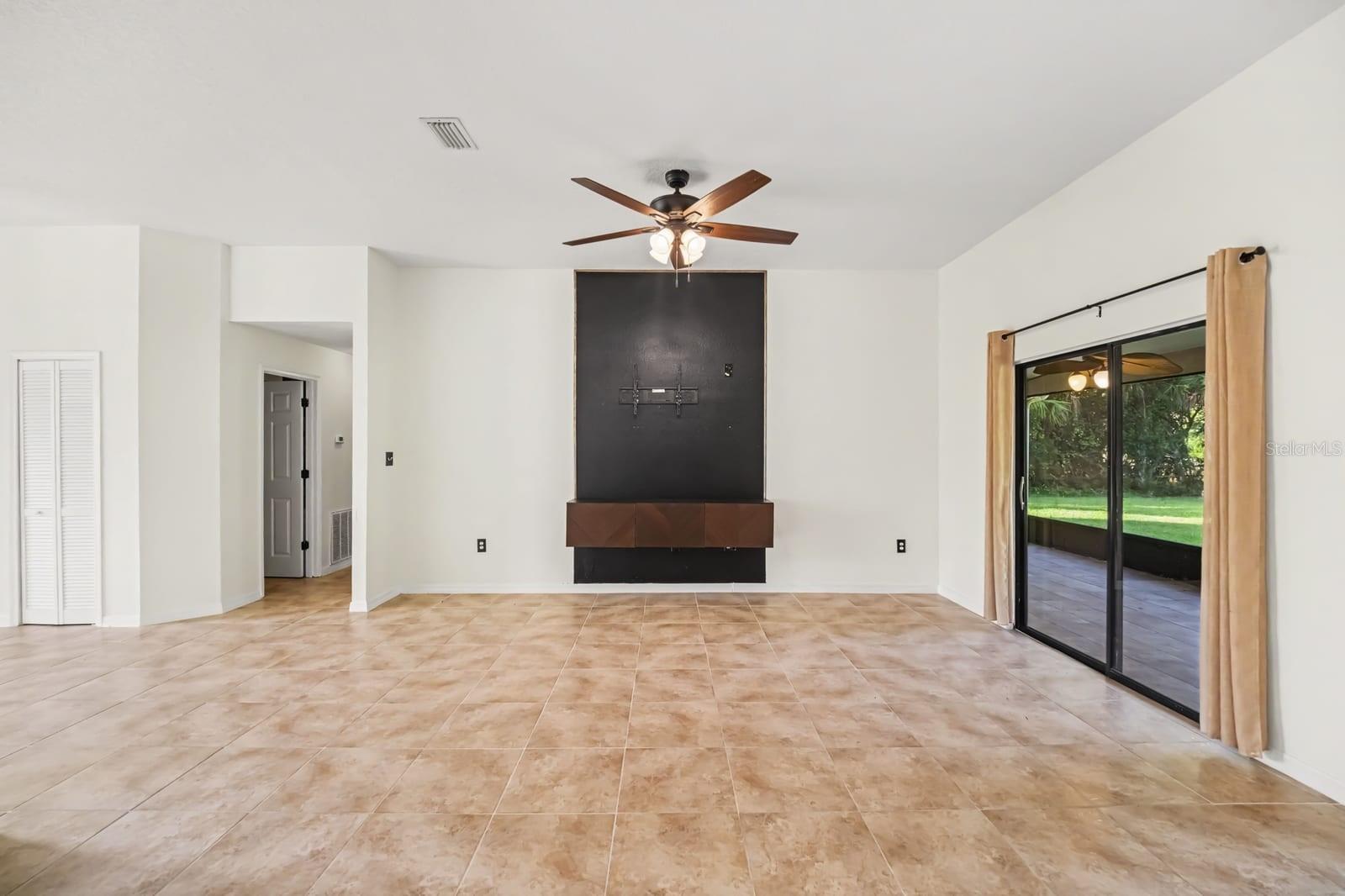 Spacious Great Room With Tile Flooring, Built-In Entertainment Center & Sliding Glass Doors