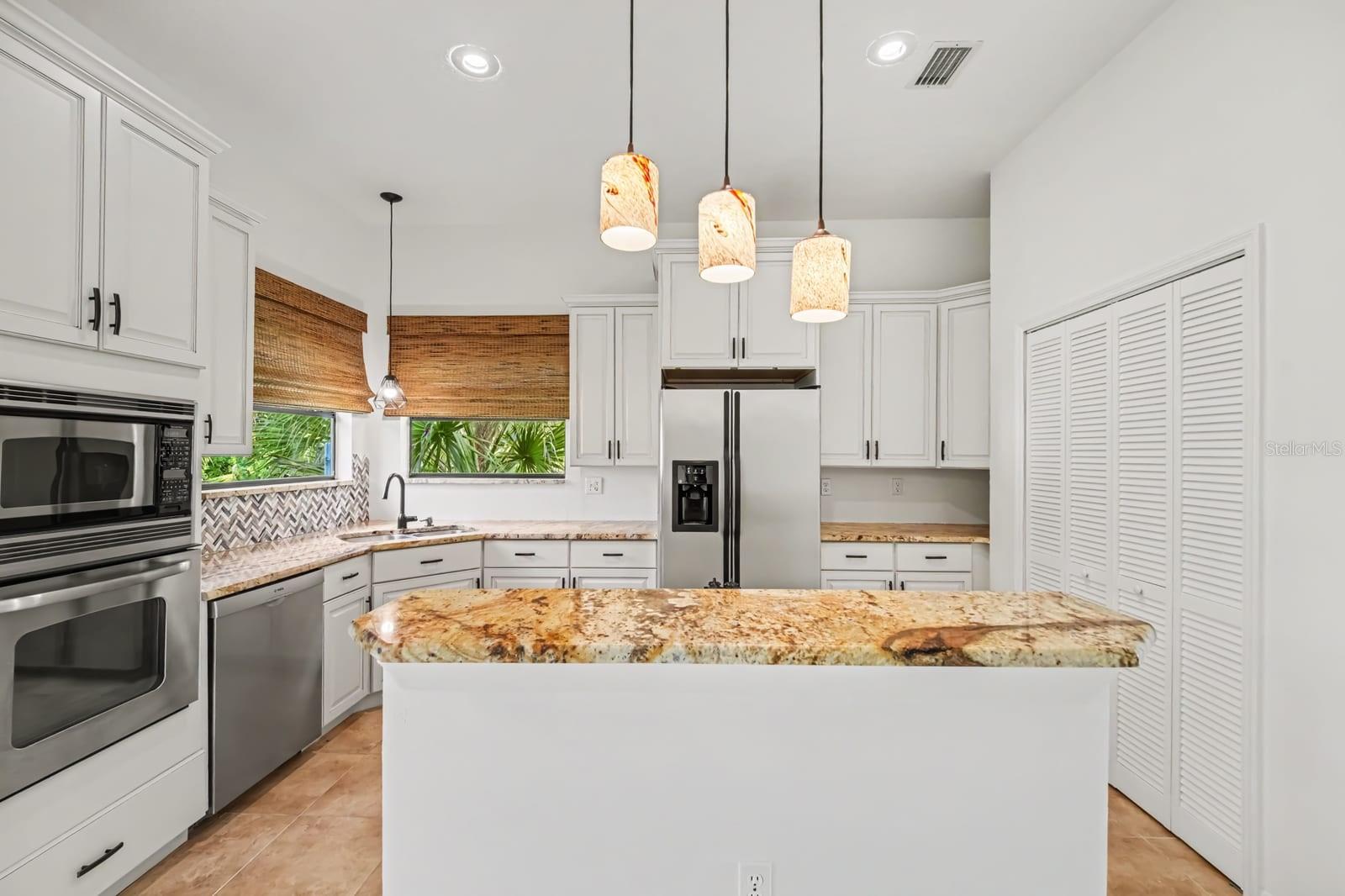 Modern Kitchen With Large Island, Glass Pendant Lights & Herringbone Backsplash