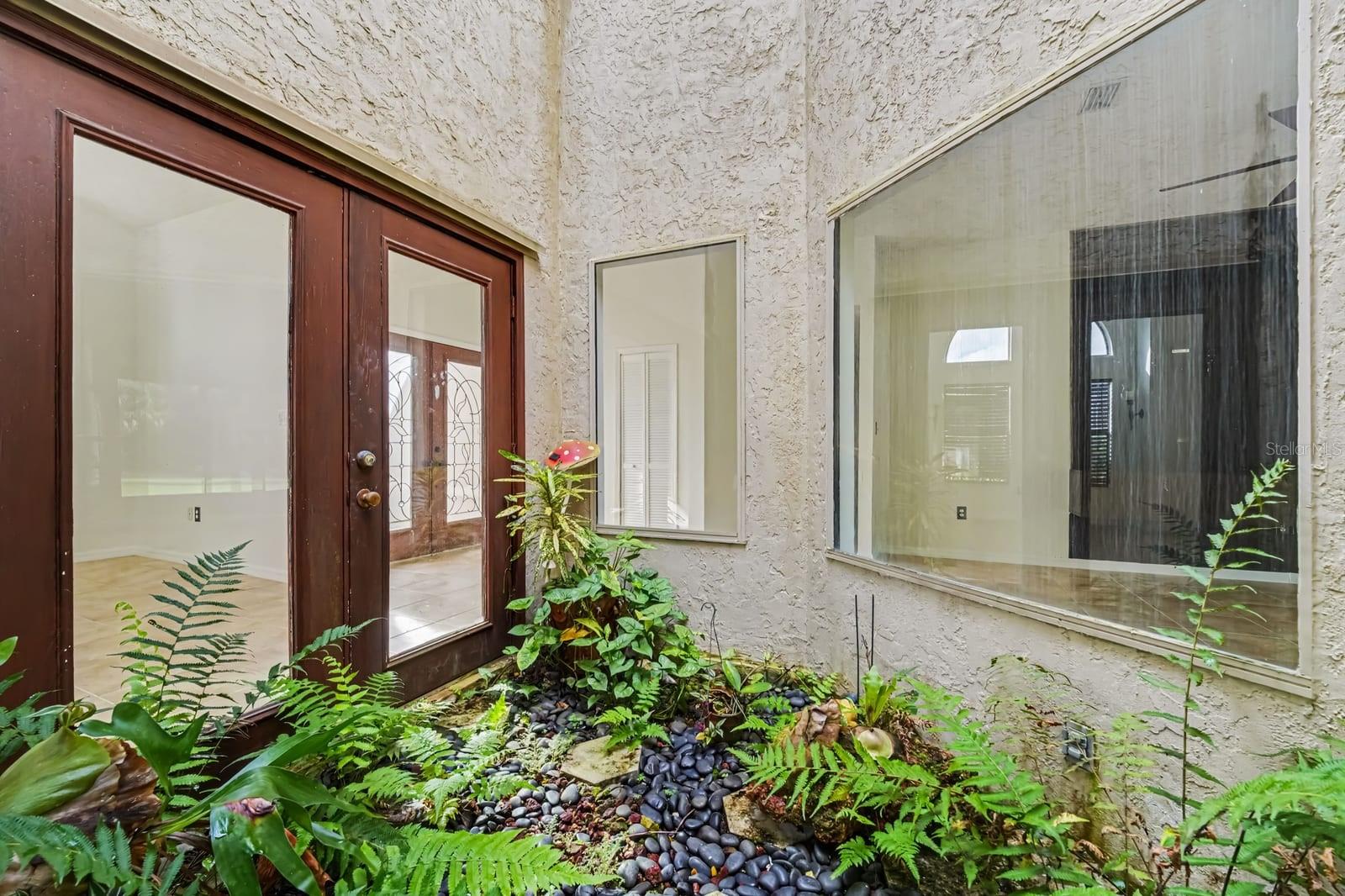 Covered Patio With Stuccoed Exterior and Glass Doors