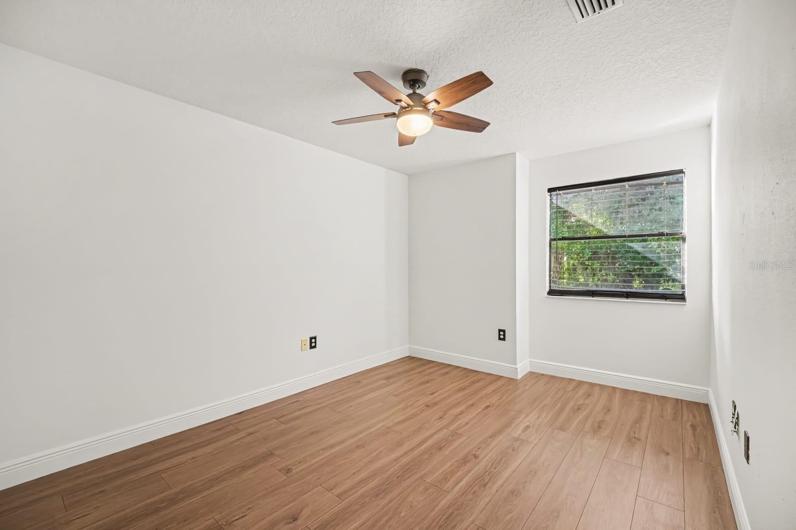 Bright Secondary Bedroom With Hard Flooring, Ceiling Fan, and Large Window
