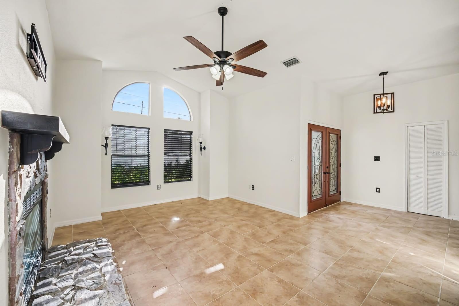 Living room flows to entry with architectural arch details and views