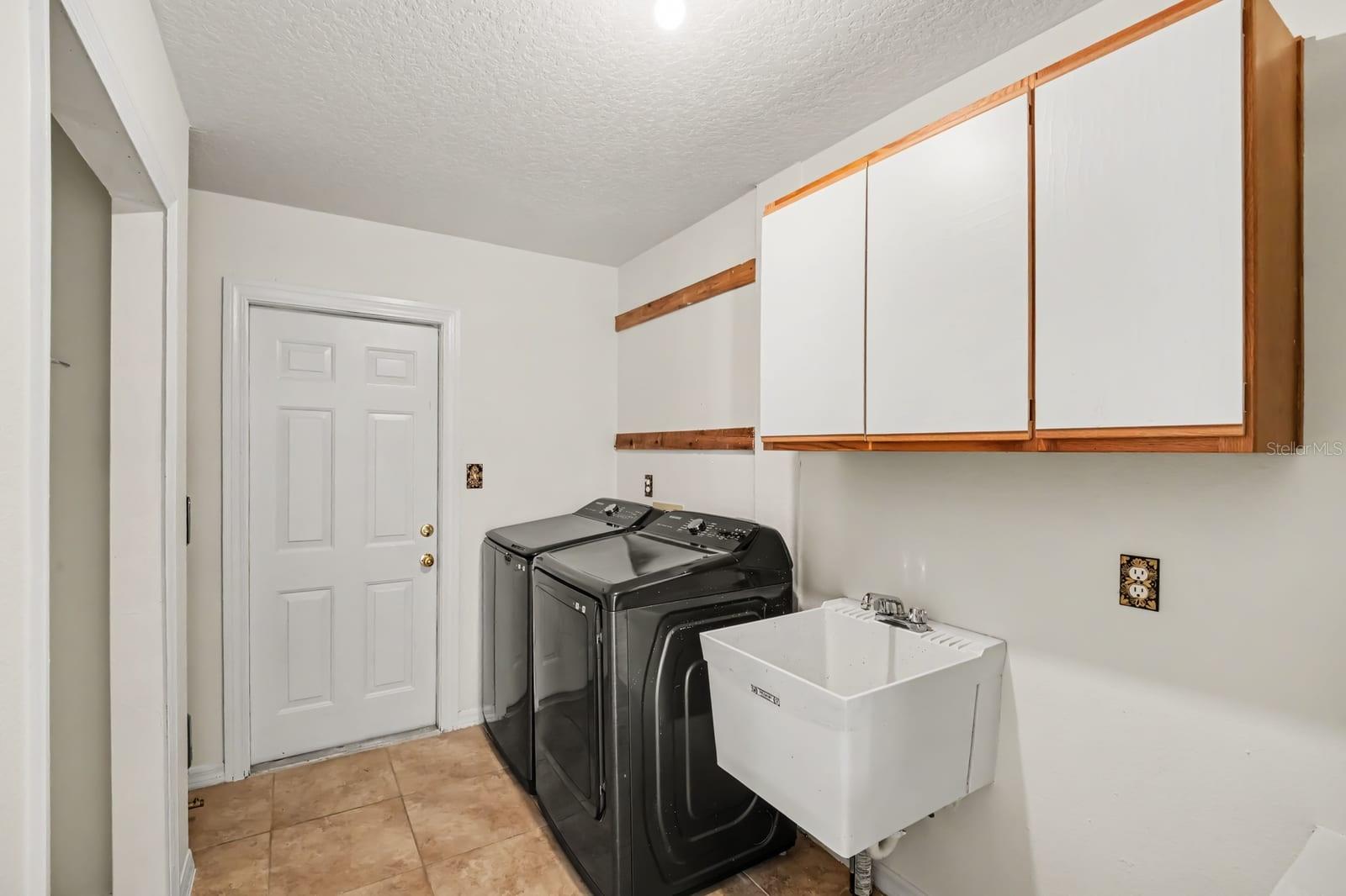 Dedicated Laundry Room With Cabinetry and Utility Sink