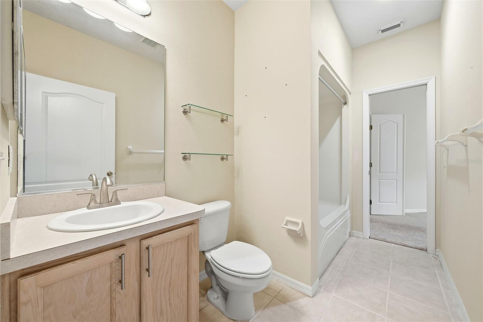Guest Bath with tub/shower combination and one door to hallway next to Bedroom 2 and one door to office/den or possibly third bedroom suite