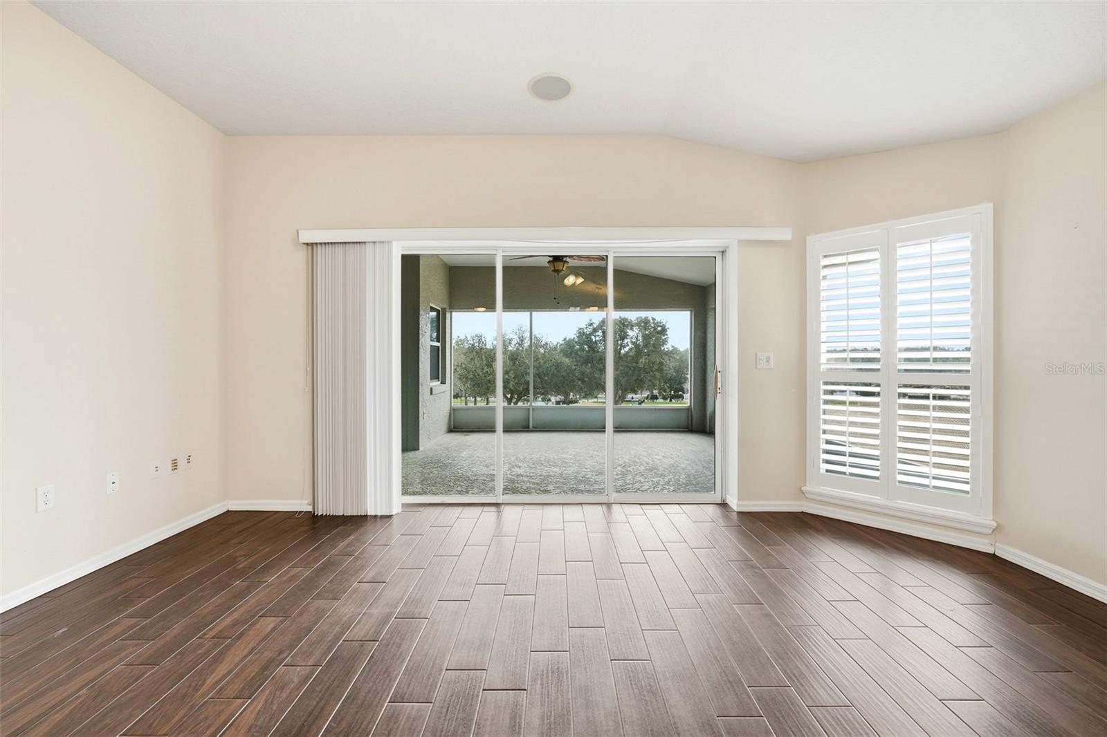 Great Room with plantation shutters and pocket triple sliding doors to lanai with golf course view!