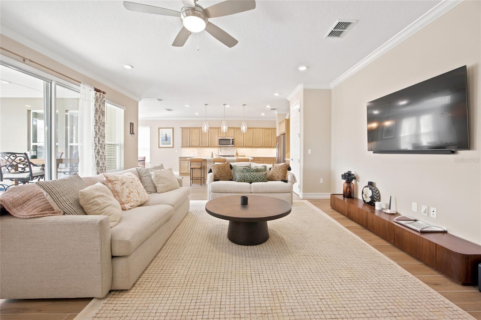 Spacious living room offering an open view into the kitchen and access to the covered patio.
