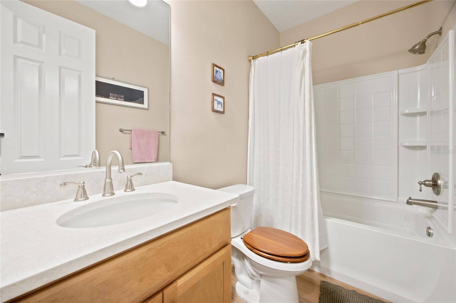 Full guest bathroom with vanity and tub/shower combination.