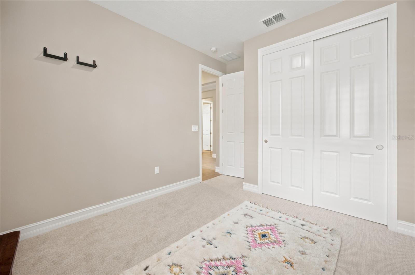 Additional view of the secondary bedroom showing its double-door closet.