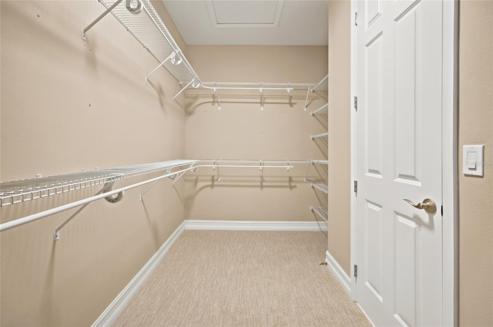 Generous walk-in closet with wraparound shelving and hanging space.