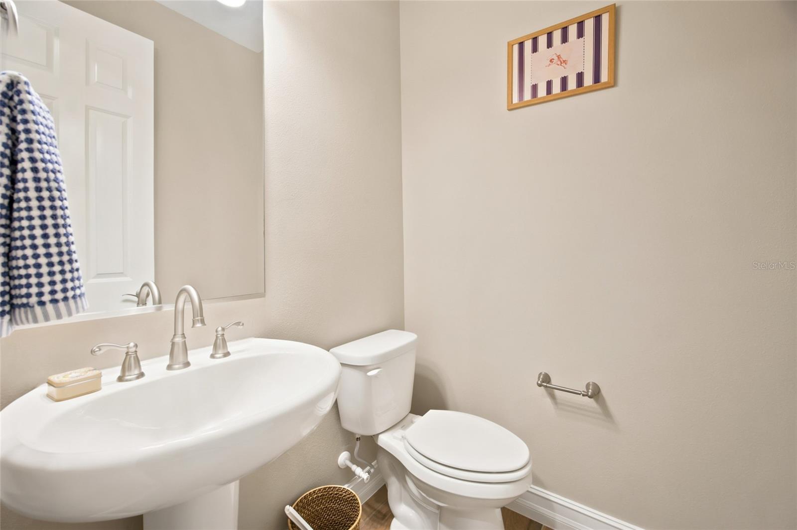 Convenient half bathroom with pedestal sink.