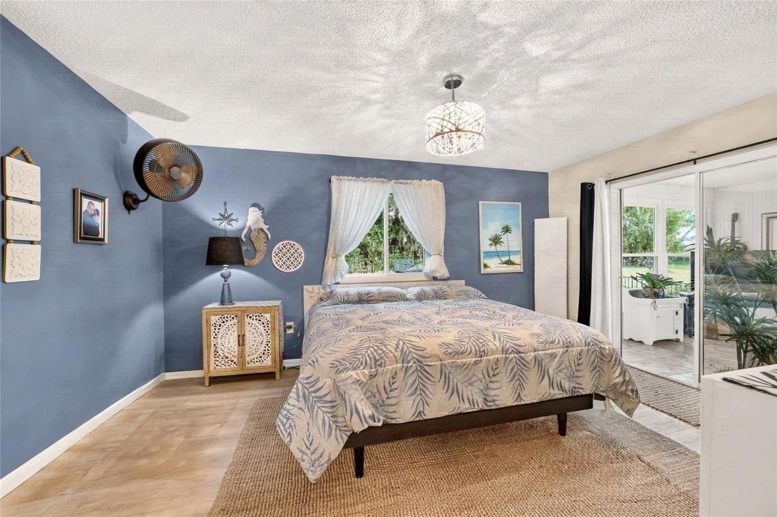 Primary Bedroom with direct access to the Florida room with sliders for light and curtains for privacy. Its the best of both worlds. Private Lot with lots of natural light. A pretty view from every room