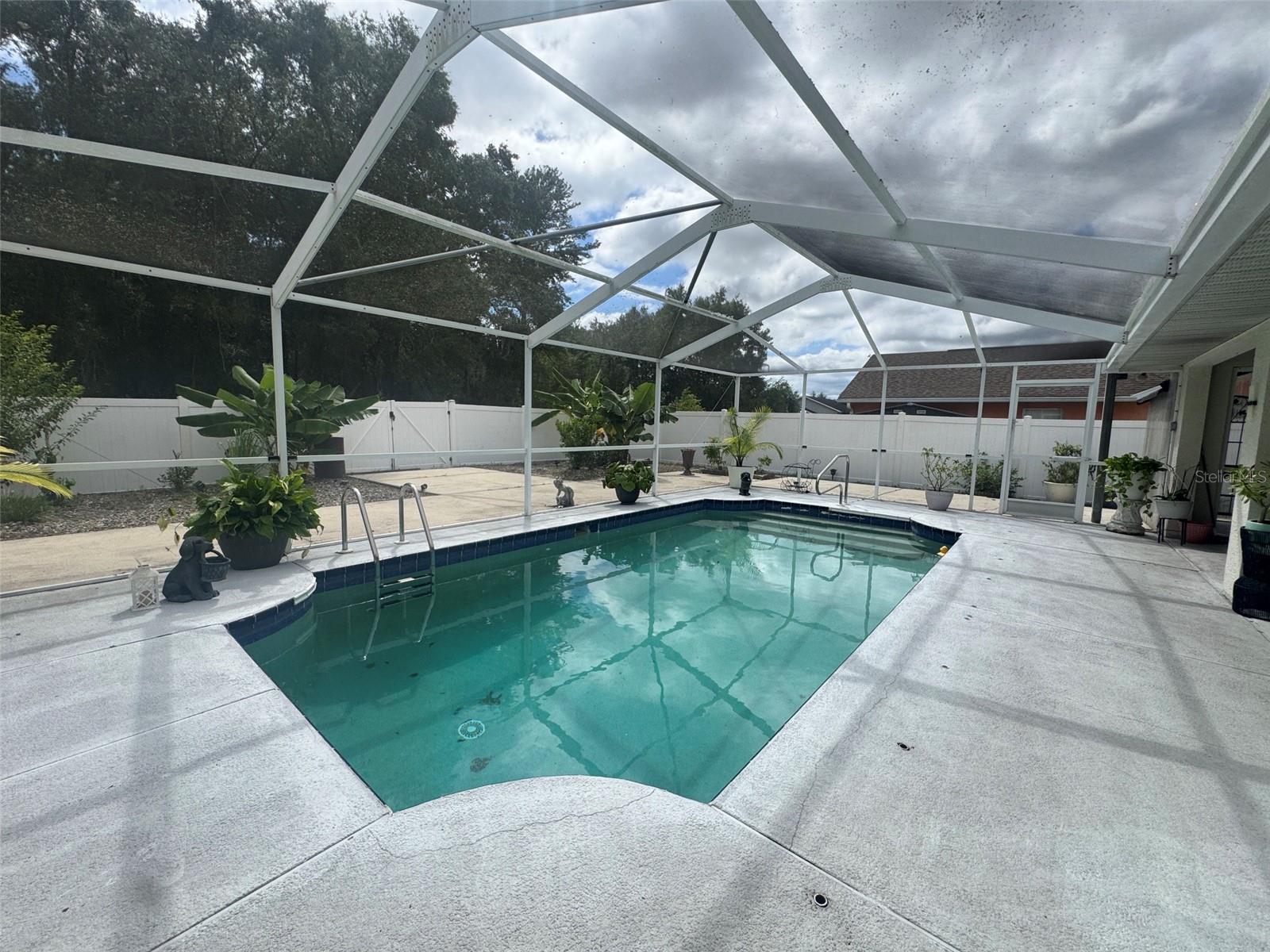 In-ground concrete pool screened