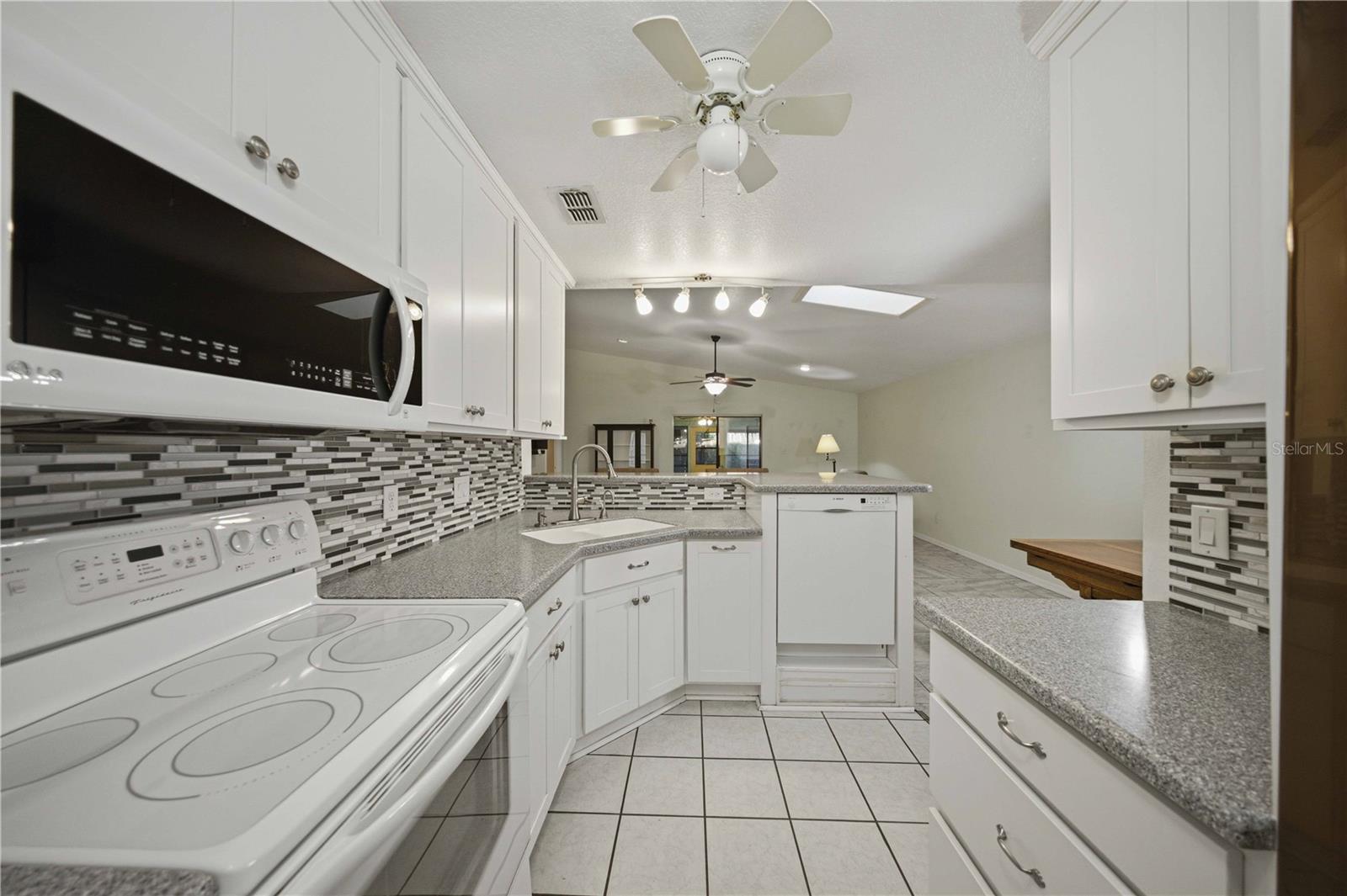 View from back of kitchen overlooking the great room, breakfast bar, and dinning area