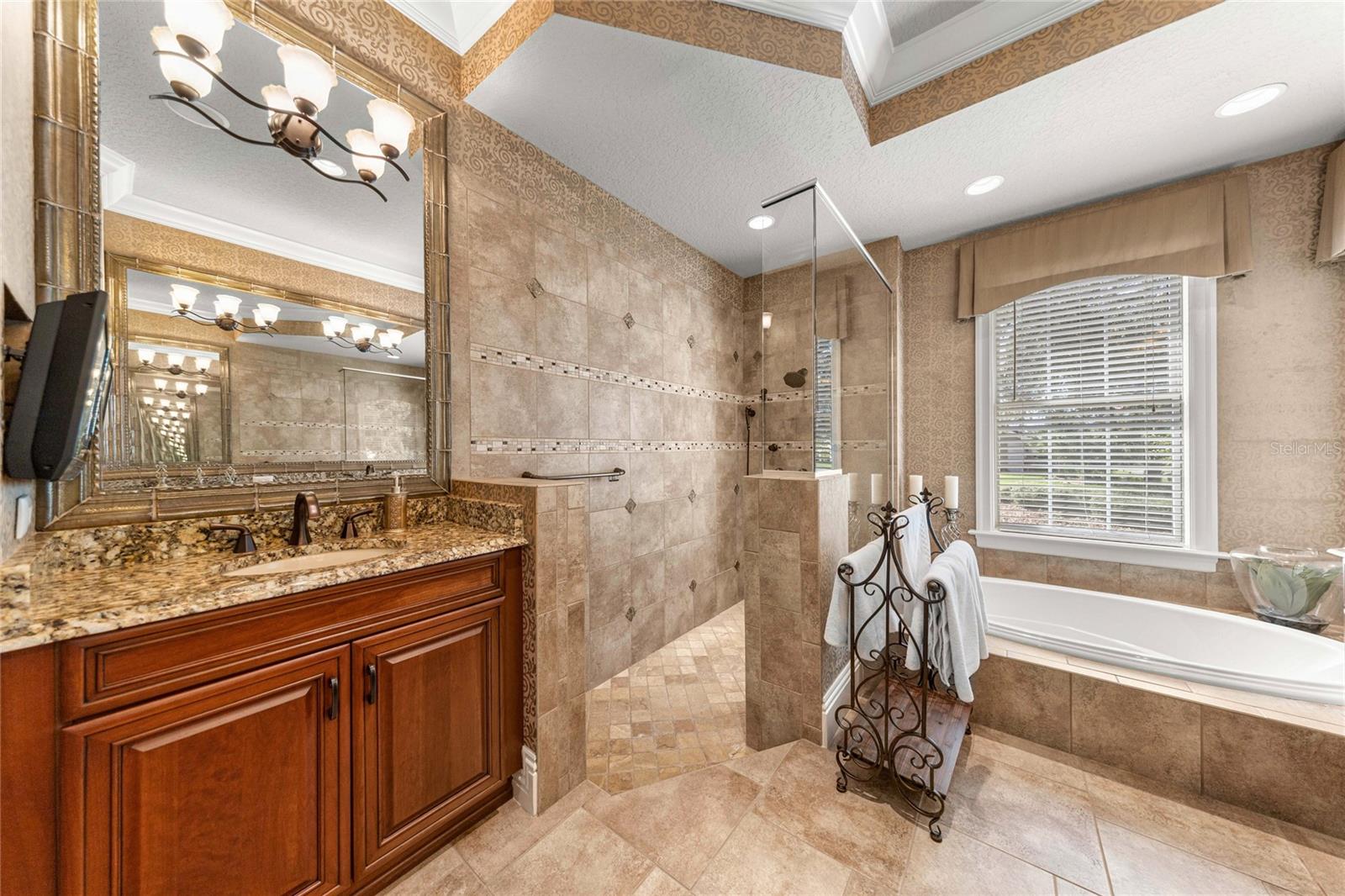 Spa-inspired owner's bathroom featuring a beautifully tiled walk-in shower, soaking tub, and elegant finishes.