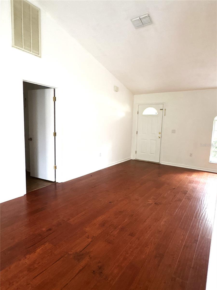 Looking at front door from dining area.  Laundry room with access to the garage is the open doorway.