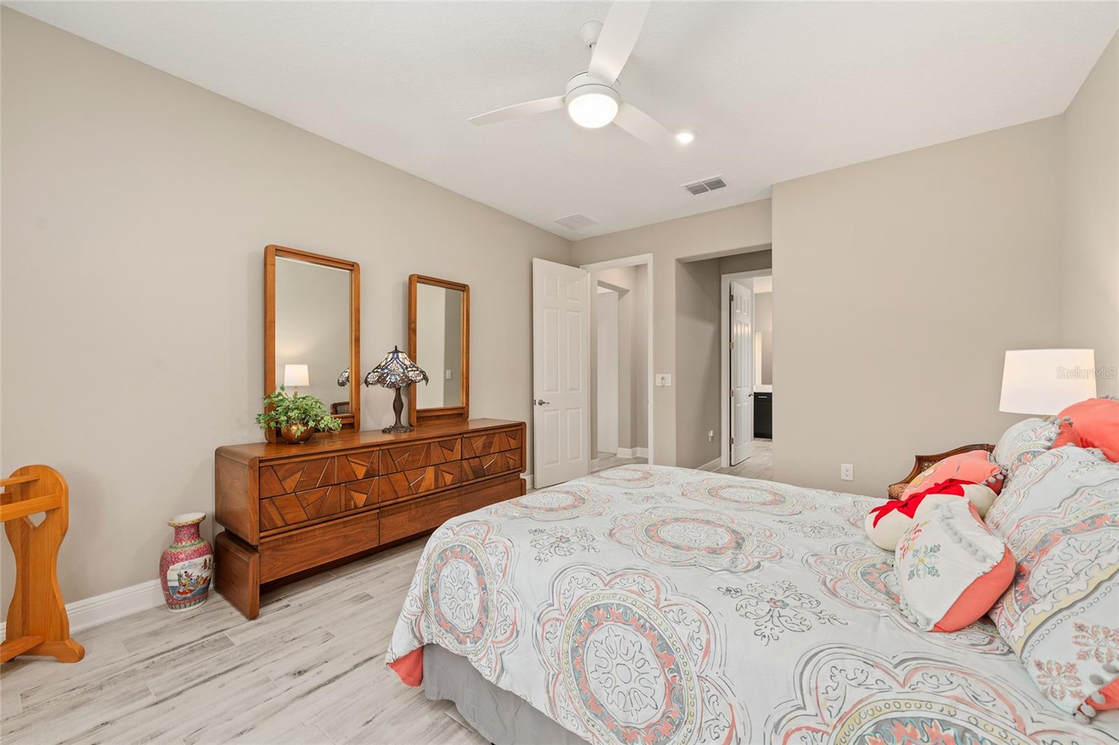 Another view of the spacious second primary suite, highlighting a convenient alcove and direct access to the private ensuite bathroom, offering a comfortable and functional retreat.