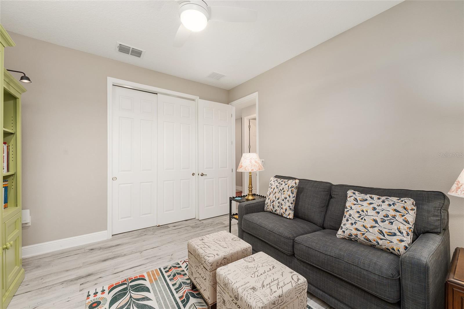 Another perspective of the third bedroom, highlighting the double sliding closet doors and generous storage space, adding functionality to this versatile room currently used as a den.